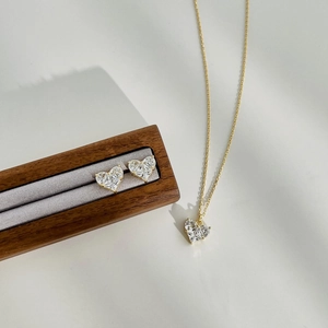 Detail of heart-shaped S925 silver jewelry set with sparkling zircon in gold plating