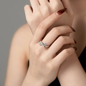 Primo piano dell'anello a fiocco in argento S925 con gemma blu indossato