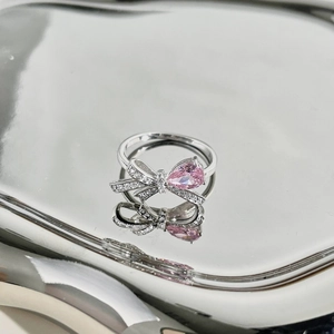 Dettaglio macro dell'anello a fiocco in argento S925 con zircone rosa a goccia e pavé