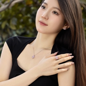 Detail view of a pink zircon four-leaf clover jewelry set worn by a female model