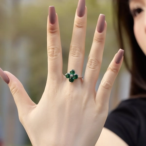 Macro shot of silver ring with four-leaf clover green zirconia stones on model finger