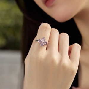 Detail of a silver clover ring with pink pear-cut zircon stones on a model's hand