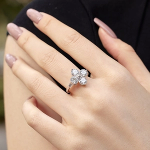 Detailed view of a silver S925 four-leaf clover ring with zircon on a model's finger