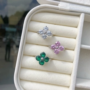 Three sterling silver four-leaf clover rings with white, pink, and green zircon in a box