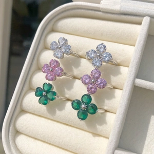Detail of S925 silver clover rings set with white, pink, and emerald green zircon stones
