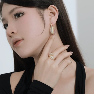 Détail de la bague et des boucles d'oreilles en forme de feuille dorée avec zircone