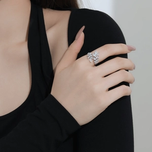 Detailed view of S925 sterling silver ring with sparkling zircon leaf design on finger