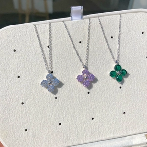 Close-up of S925 sterling silver necklaces with colorful clover-shaped zircon pendants