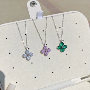 Close-up of S925 silver four-leaf clover necklaces in white, pink and emerald green
