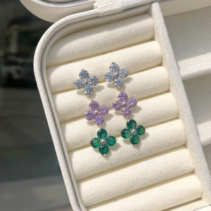 Macro shot of silver clover stud earrings set with white, pink and emerald cubic zirconia