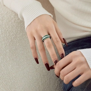 Close-up of S925 silver stacked rings with emerald green and white zircon pavé setting