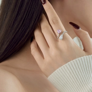 Detail of S925 silver ring featuring pink heart and white teardrop cubic zirconia on finger