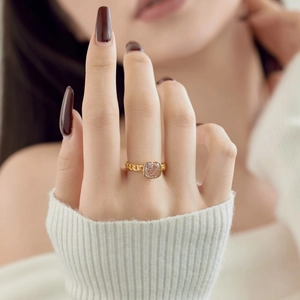 Detail of gold chain-style silver ring featuring a square-cut champagne stone on finger
