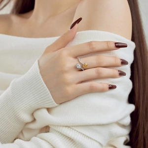 Detail of S925 silver ring featuring pear-cut yellow and white stones in a crossover design