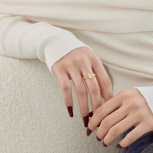 Detail of Cuban link gold ring featuring a large square-cut clear zircon on a finger