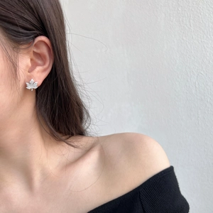 Close-up of S925 silver maple leaf earrings with cubic zirconia on a model's ear