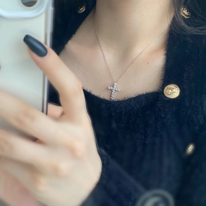 Dettaglio della collana con ciondolo a croce in argento 925 e zirconi su modella