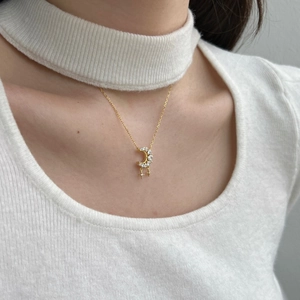 Detailed view of a gold crescent moon and star necklace with zircon inlays on neck