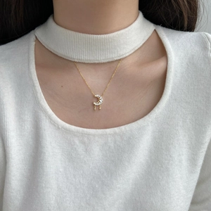 Detailed close-up of a crescent moon and star pendant necklace with zircons on a model