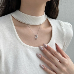 Detail of S925 silver moon necklace with pavé zircon stones and star tassel on a model