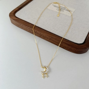 Detail of crescent moon and star pendant with zircon inlay on a gold snake bone chain