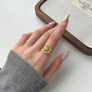 Macro detail of gold celestial ring featuring sparkling crescent moon and sun design