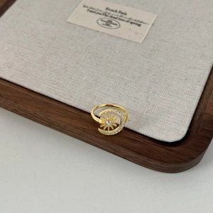 Detailed view of gold sun and moon open ring with sparkling white zircon stones