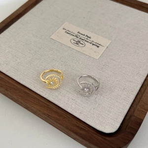Detail of sun and moon open rings with zircon inlay in gold and silver finishes