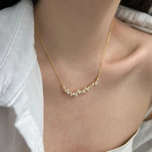 Close-up of a smile-shaped gold pendant necklace with marquise and round zircon stones