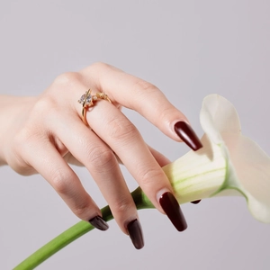 Detailed view of elegant gold ring with clear heart-cut zircon and beaded band on model