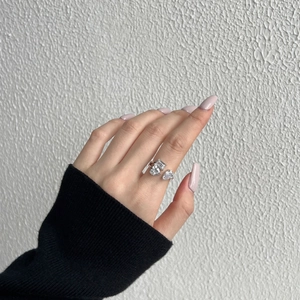 Détail d'une bague S925 argentée avec zircons en forme de cœur, rectangle et goutte