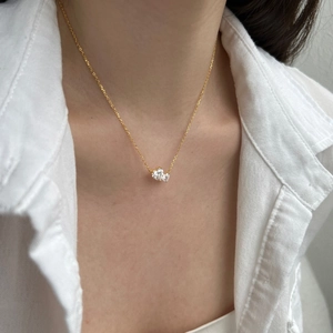 Detail of interlocking double heart pendant with zircon pavé on a thin gold chain