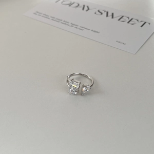 Vue détaillée d'une bague argentée avec zircon en cœur et pierres géométriques