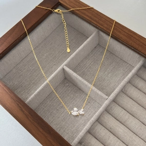 Macro detail of S925 silver gold-plated necklace with double heart cubic zirconia