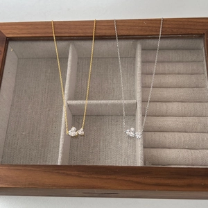 Detailed close-up of S925 sterling silver double heart zircon pendants in a wooden box