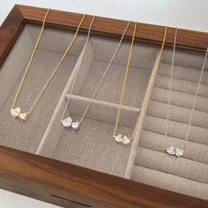 Detail of silver and gold double heart necklaces with clear cubic zirconia in jewelry box