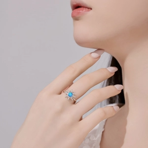 Close-up of sunburst ring with blue opal stone and rose gold twisted band