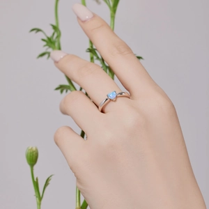 Bague en argent sterling S925 avec opale bleue en forme de cœur sur une main