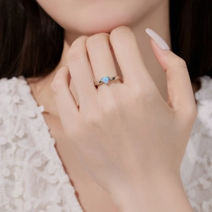 Bague élégante en argent S925 avec opale bleue en forme de cœur portée par un mannequin