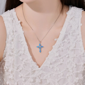 Elegant S925 sterling silver cross necklace with blue opal pendant on a female model