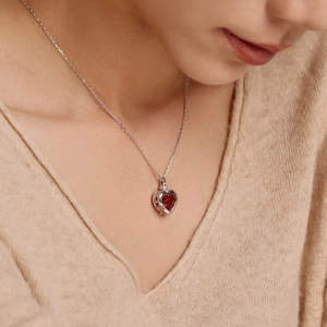 Detail of a red heart-shaped gemstone pendant on a S925 sterling silver chain
