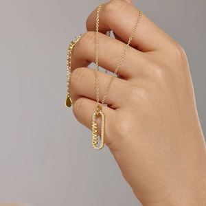 Détail du pendentif doré MAMA avec lettres ajourées et sertissage de zircons blancs