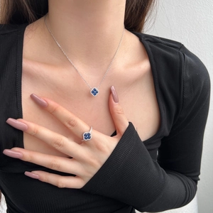 Détail du collier et de la bague trèfle en argent S925 avec zircons bleus sur mannequin