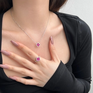 Vue détaillée du parure collier et bague trèfle en argent avec pierres rouge rose
