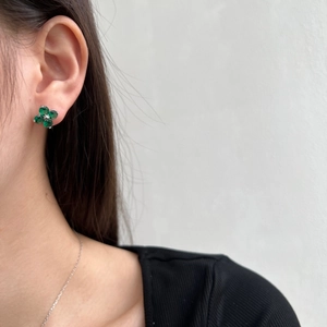 Close-up of S925 sterling silver four-leaf clover stud earring with green zircon on ear