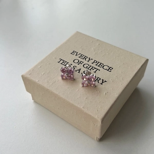 Macro detail of S925 sterling silver four-leaf clover earrings with pink zirconia stones