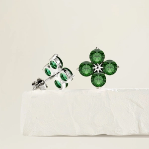 Macro detail of S925 silver four-leaf clover stud earrings with green zircon stones