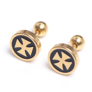 Macro detail of gold stainless steel barbell studs with black iron cross design