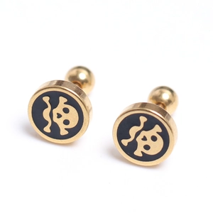 Vue détaillée des boucles d'oreilles punk tête de mort dorées avec insert noir rond