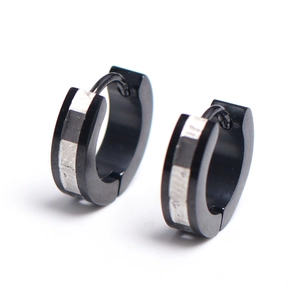 Détail de boucles d'oreilles créoles en acier noir mat avec motif en damier argent